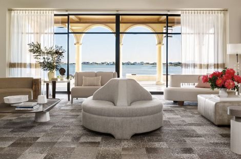 A beautiful, Tusan modern inspired Hamptons home, featuring a custom roundabout, and curved sectional with wood back. Penny Drue Baird/Dessins. Bespoke by LG