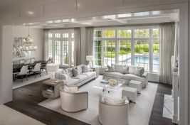 Beautiful grey and white tonal, Palm Beach living room featuring our Felix Chairs, custom Greenwich and upholstered love seat with a waterfall skirt. Interiors: Robyn Karp Design.