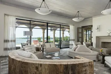 Fabulous custom upholstered curved sectional with wood back in a luxurious Tuscan modern inspired space.