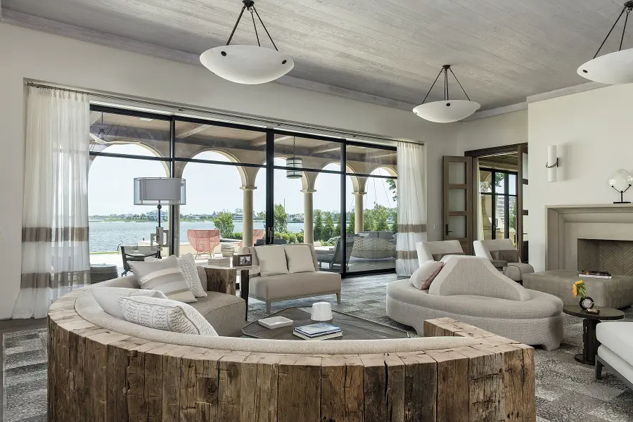 Fabulous custom upholstered curved sectional with wood back in a luxurious Tuscan modern inspired space.