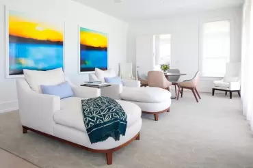 Soft white linen chaises with curved walnut bases, plush cushions, and serene coastal elegance—perfect for relaxed modern interiors.