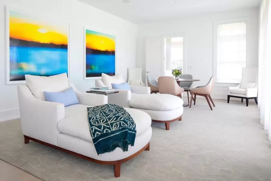 Soft white linen chaises with curved walnut bases, plush cushions, and serene coastal elegance—perfect for relaxed modern interiors.