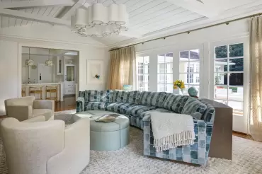 A custom Whitehall curved sofa is in bright light with our oak custom built bookcase in the rear to follow the curve. Impressive design creativity by Penny Drue Baird.