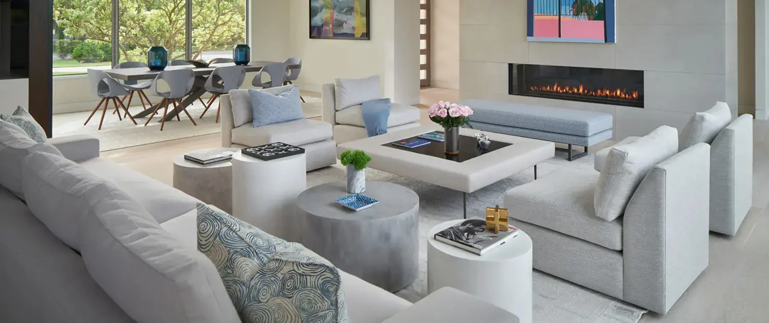 Beautiful Palm Beach tonal grey and blue living room featuring our custom upholstered armless Cape May chairs, Hollis Ottoman, and Beekman S